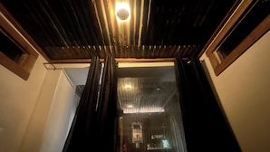 A narrow hallway with wooden walls and a ceiling light fixture.