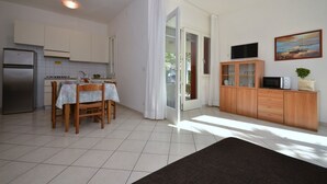 Una cocina moderna con una mesa de comedor, armarios y un refrigerador.