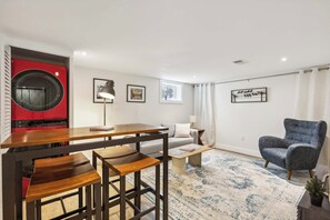 Ein modernes Wohnzimmer mit einem roten Gerät, einem Sofa, einem Couchtisch und einem Sessel.