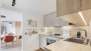 Une cuisine moderne avec des meubles en bois, un four encastré et un évier.