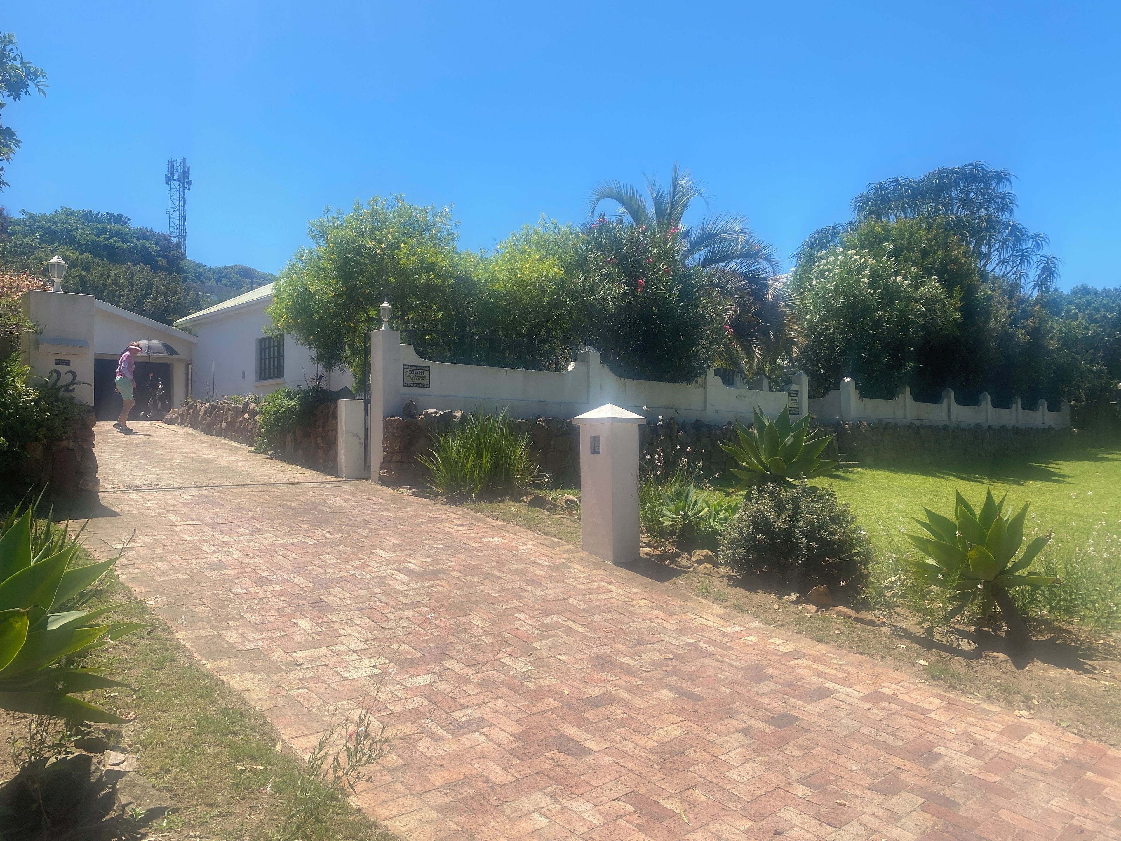 A paved pathway leading to a building with a sign indicating a parking area.