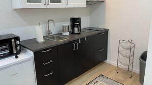 A compact kitchen with a Bosch coffee maker, a toaster, and a sink. - Living by the historic town hall (Michelstadt)