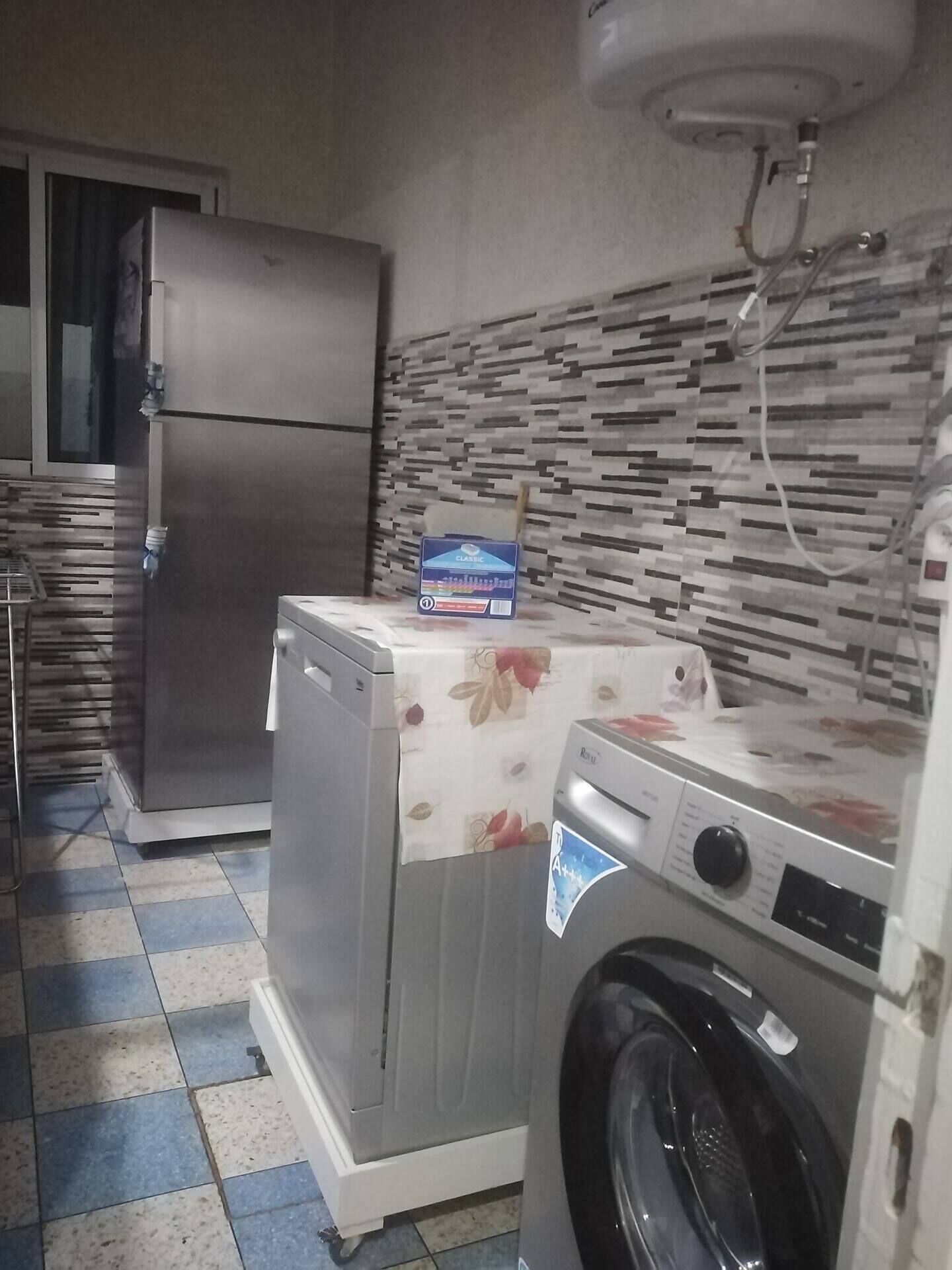 A laundry area with a washing machine, a dryer, and a refrigerator.