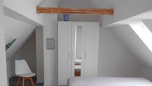 A small, compact room with a bunk bed, a white wardrobe, and a chair. - Quiet vacation home with lots of space (Masserberg)