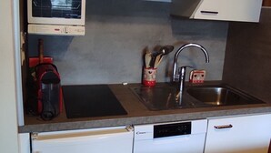 A compact kitchen with a microwave, a sink, and a dishwasher.