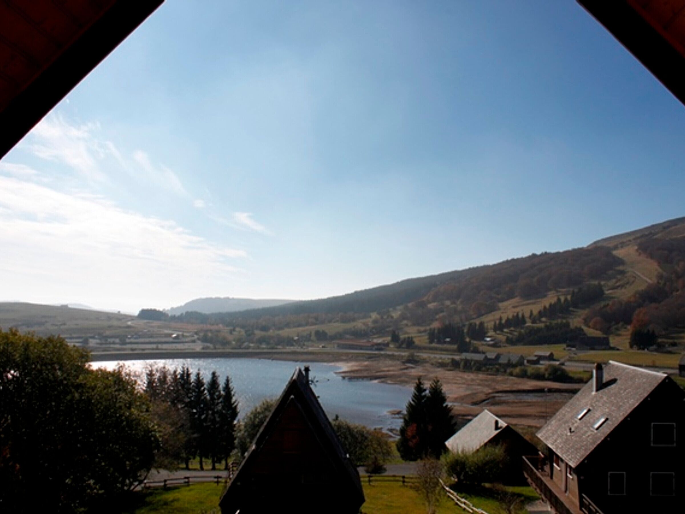 A view of a valley with a river, surrounded by hills and houses.