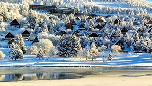 A winter scene with snow-covered cabins and a frozen lake. - Apartment at the slopes with private garage (Besse-et-Saint-Anastaise-Super Besse)