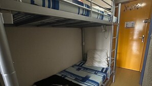 A bunk bed with a striped bedspread and a pillow, a metal ladder, and a door with a sign. - Studio cabin 4 pers, center, WIFI (Besse-et-Saint-Anastaise-Super Besse)
