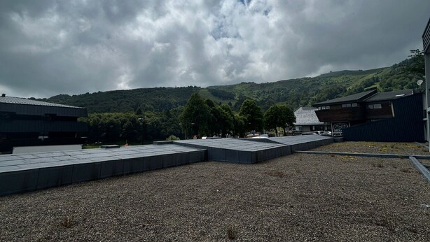 A building with a flat roof and a gravel ground. - Studio cabin 4 pers, center, WIFI (Besse-et-Saint-Anastaise-Super Besse)