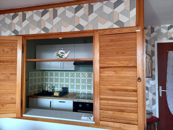 Eine Küche mit Holzausstattung, einer Arbeitsplatte und einer Spritzschutzleiste mit geometrischen Mustern.