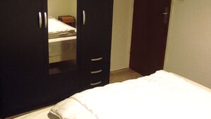 Een slaapkamer met een bed, een kledingkast en een spiegel.