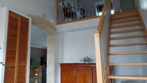 A staircase with wooden steps and a railing, leading to a balcony with a view of outdoor furniture. - Cosy house just outside Tours  (Saint-Branchs)