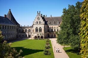 A historic building with a central courtyard, arched windows, and a clock tower.