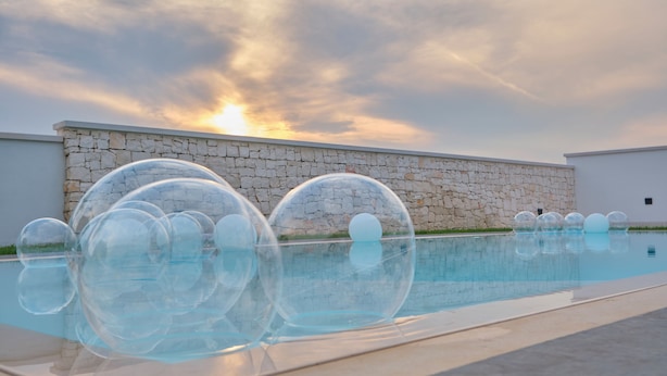 Una piscina amb aigua cristal·lina i diverses boles transparents.