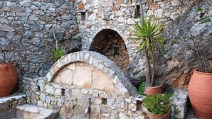 A stone wall with a small archway and potted plants. - Melina Dream House Retreat at Akoumia (Agios Vasileios)