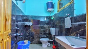 A bathroom with a toilet, sink, shower, and a blue bucket. - Tirthan Height - Facing toward Snow View (Banjar)