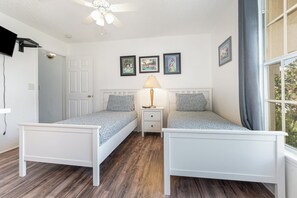 A bedroom with two beds, a nightstand, a lamp, and framed pictures on the wall. - Family Home w/ Pool & Water Views, Near Disney (Kissimmee)