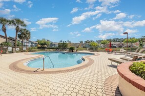 A swimming pool with a hexagonal tile pattern, surrounded by lounge chairs and palm trees. - Family Home w/ Pool & Water Views, Near Disney (Kissimmee)