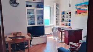 A modern living space with a dining area, kitchen, and bar. - Charming sea view apartment for families, with sky tv (Riomaggiore)