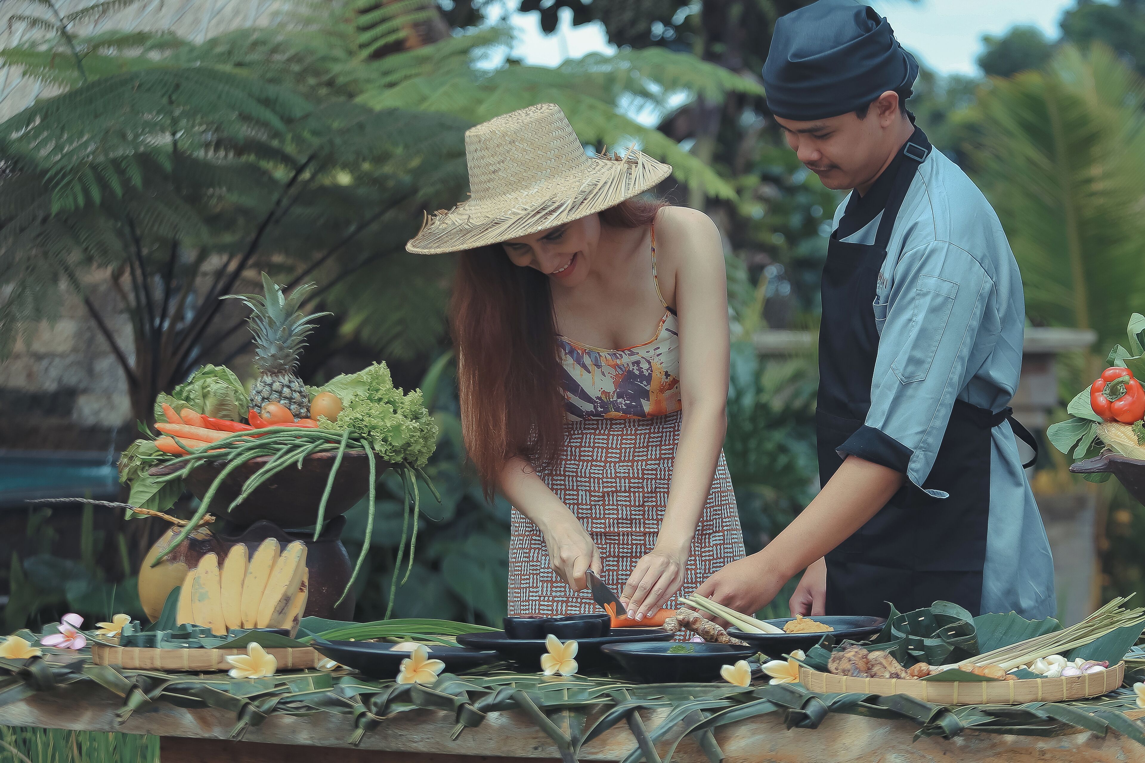 A person preparing food with vegetables and fruits on a table.