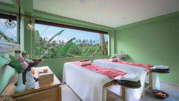 Relax in a serene space with two massage tables, a wooden bench, and a view of lush greenery.