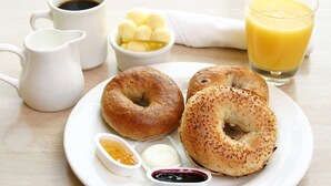 A breakfast plate with two bagels, butter, cream cheese, and jams. - Hotel Crystal INN (Bhubaneshwar)