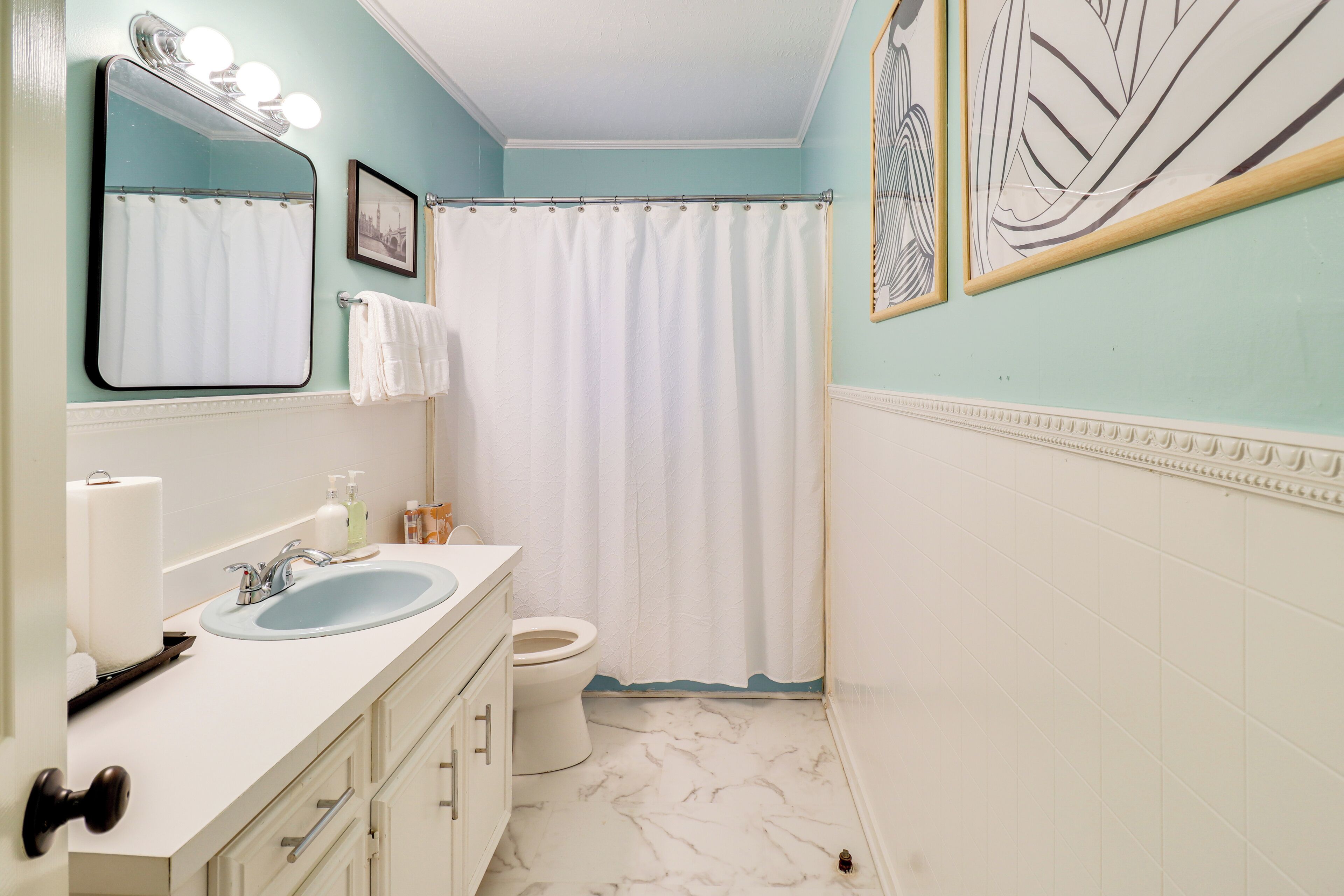 A bathroom with a sink, mirror, and toilet.