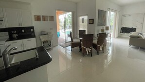 A spacious living area with a kitchen, dining table, and a sofa.