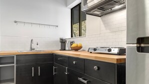 A modern kitchen with a stainless steel refrigerator, a wooden countertop, and a black cabinet with drawers. - Tomboy Lodge 144 1 Bedroom Condo (Telluride)