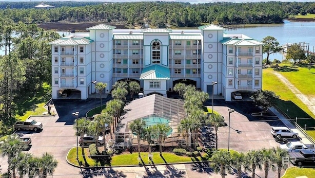 Un hotel grande con varios pisos, un patio central con piscina y vistas al lago.