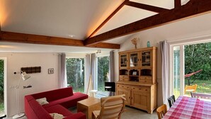 Ein gemütliches Zimmer mit einem roten Sofa, einem Holzespeisetisch und einer Vitrine.