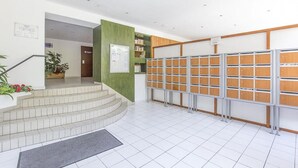 A reception area with a staircase, a bulletin board, and a row of lockers.