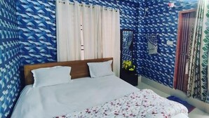 A bedroom with a bed, curtains, an air conditioner, and patterned walls. - Hotel Moon International  (Dhaka)