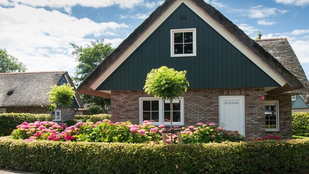 A traditional house with a steeply pitched roof, a small front porch, and a brick facade. - Villa Close to Forest, Beach & sea (Sint Maartensvlotbrug)