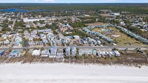 Vista aérea de una zona residencial costera con casas, una playa y una extensa masa de agua.