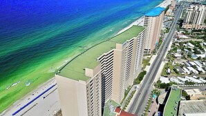 Ein Küstenhotel mit mehreren Hochhäusern, einem Strand und einer Straße mit Fahrzeugen.