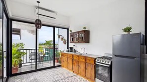 A modern kitchen with a gas stove, refrigerator, and wooden cabinets.
