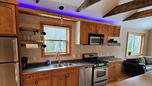 A kitchen with wooden cabinets, a stainless steel refrigerator, a microwave, a stove, and a sink. - High-alpine private retreat 2-bedroom house in cozy Alma, close to Breckenridge (Alma)