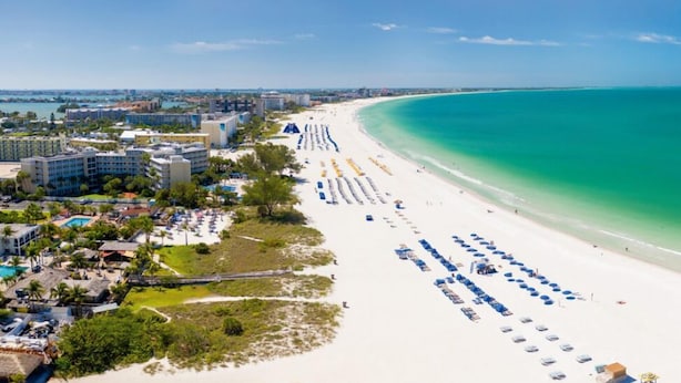 A coastal hotel with a beach view, multiple swimming pools, and a long stretch of beach with umbrellas. - Kick back and relax in this calm, stylish home! Close to downtown, beaches, park (St. Petersburg)