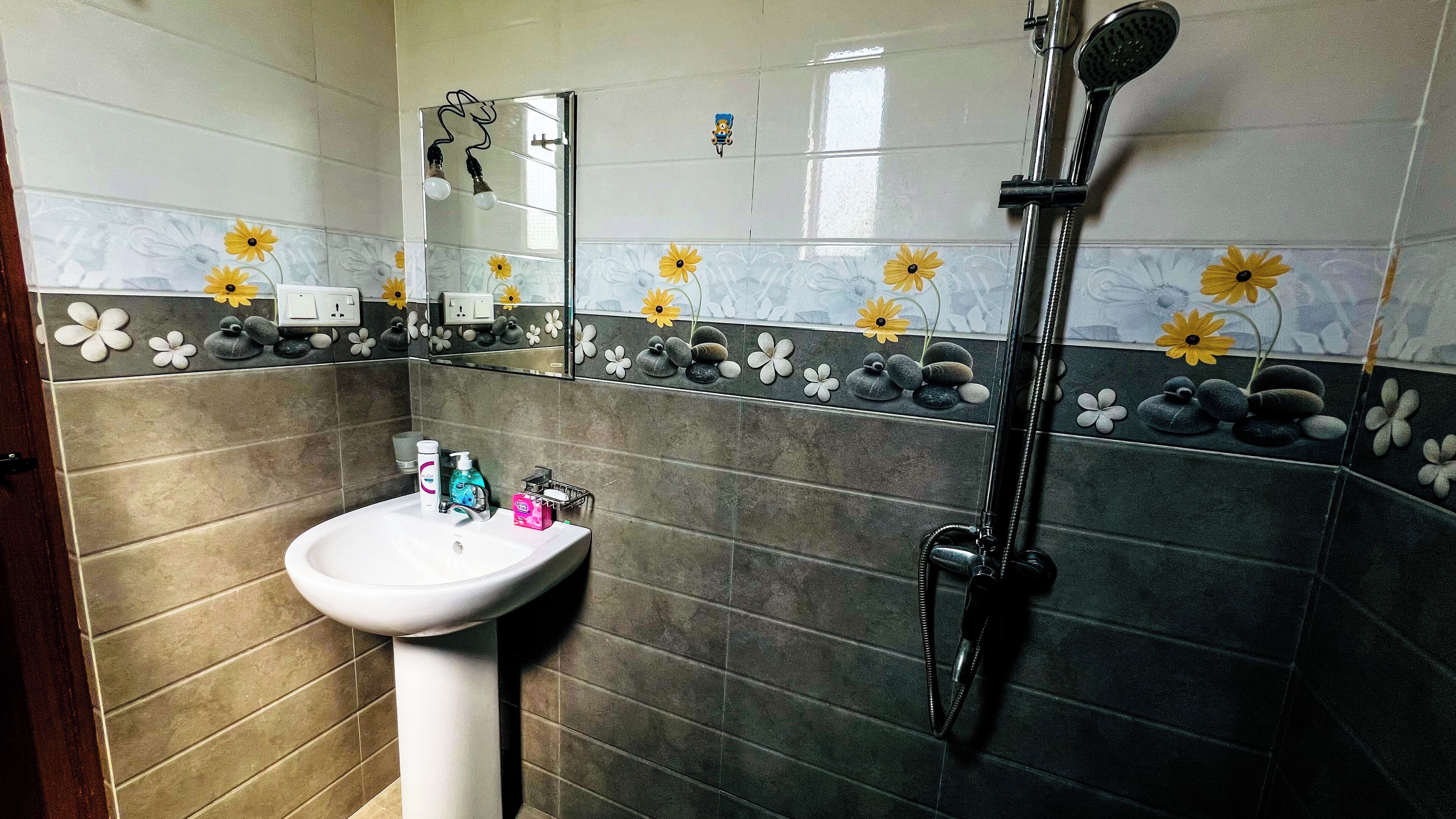 Un baño con lavamanos, espejo y ducha.