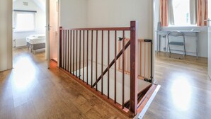 A room with a wooden floor, a bed, a radiator, and a window with curtains. - Luxurious Coastal Villa Near Forest (Sint Maartensvlotbrug)