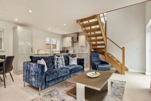 Relax in a comfortable living space with a sofa, dining table, and modern kitchen area.