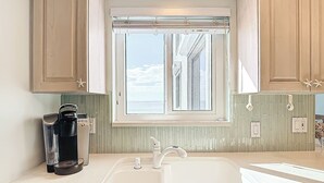 A kitchen with a window, a sink, and a coffee maker.