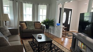 A living room with a sofa, coffee table, TV, and a bookshelf. - Cozy Home in Holyoke with 3 bedrooms (Holyoke)