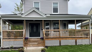 A two-story house with a front porch, a concrete walkway, and a well-maintained lawn. - Cozy Home in Holyoke with 3 bedrooms (Holyoke)