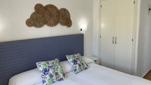 Een slaapkamer met een bed, een hoofdbord, een kledingkast en een decoratie aan de muur.