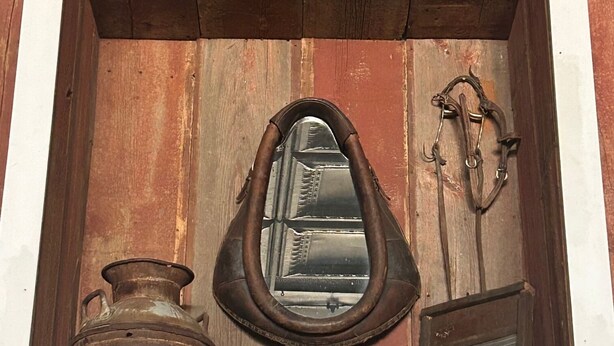 A rustic wooden cabinet with a mirror, a metal bucket, and a metal container. - The Bunkhouse – A Unique Stay in Historic Hebron, Nebraska (Hebron)