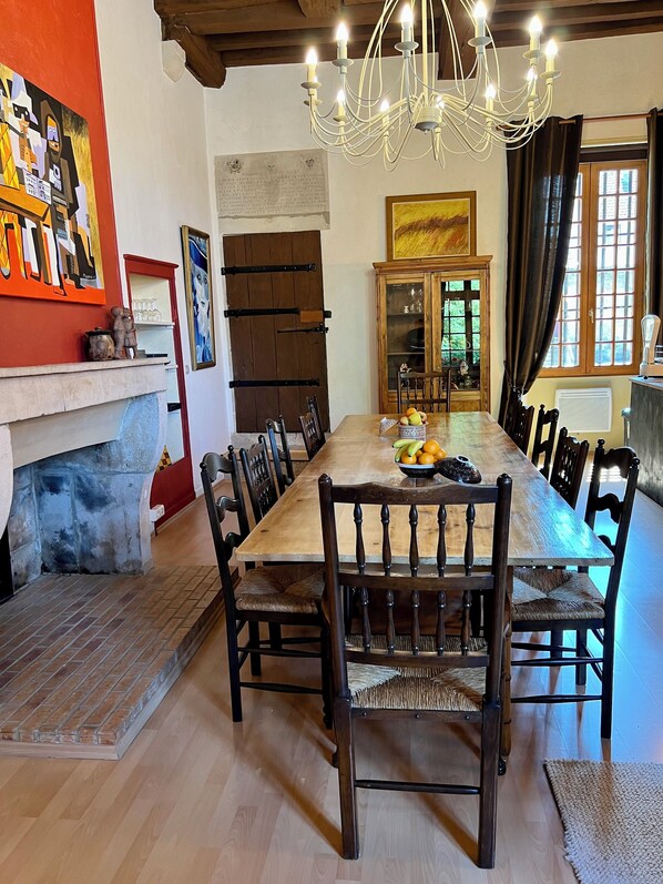 A dining room with a long wooden table, chairs, a chandelier, and a fireplace. - Auditoire Royal de Châtillon sur Seine (Châtillon-sur-Seine)