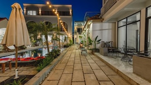A poolside area with a pathway, outdoor seating, and string lights. - Vu's Homestay Tam Coc (Nam Hoa Lu)