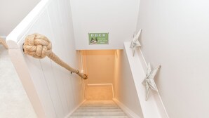 A staircase with a rope tied to the railing, a sign that says "DUCK PLEASE MIND YOUR HEAD," and star-shaped wall decorations. - PEACEFUL, CENTRAL LUXURY COTTAGE WITH PARKING,WATERSIDE TERRACE (Arundel)